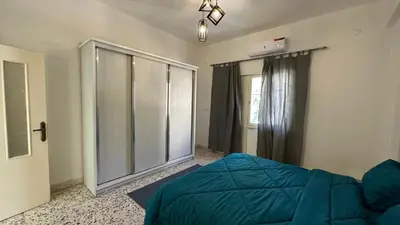 a bedroom with a blue bed and a window at Turkuaz Aparment in Amman