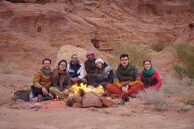 a group of people sitting around a campfire at Bedouin Nature Camp in Wadi Rum