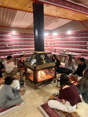 a group of people sitting around a fireplace at Bedouin Nature Camp in Wadi Rum
