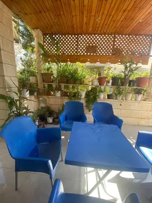 a patio with blue tables and chairs and potted plants at بيت جرش - Jerash House in Jerash