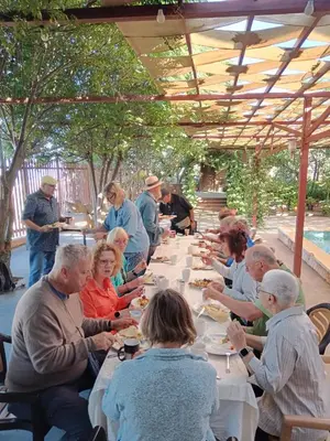 a group of people sitting at a long table eating at North Jewel 2023 in Ajloun