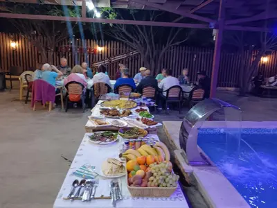 a long table with food on it next to a pool at North Jewel 2023 in Ajloun
