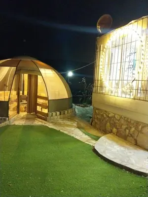 a gazebo in front of a building at night at Mount lareen cottage كوخ جبل لارين in Ajloun