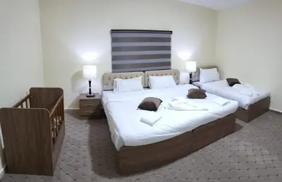 a bedroom with two beds with white sheets at Petra Hills House in Wadi Musa
