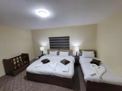a hotel room with two beds with white sheets at Petra Hills House in Wadi Musa