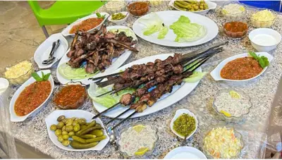 a table topped with plates of food with different foods at Petra Magic Guest House in Wadi Musa