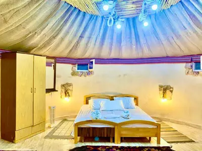 a bedroom with a bed in a tent at Pink city cottage in Wadi Musa