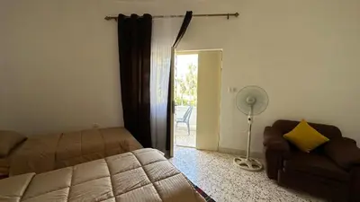 a bedroom with a bed and a couch and a fan at The vintage apartment in Amman
