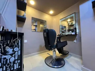 a barber shop with a black chair and a mirror at Kaya Hotel Amman in Amman