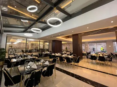 a restaurant with tables and chairs in a room at Kaya Hotel Amman in Amman