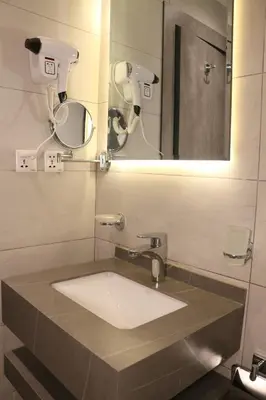 a bathroom with a sink and a mirror at Kaya Hotel Amman in Amman