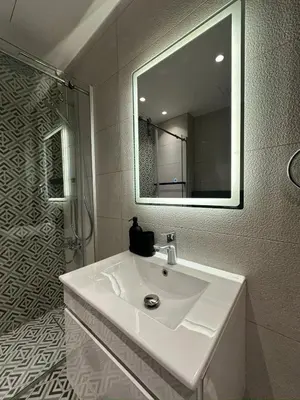 a white bathroom with a sink and a mirror at Damac Tower Amman Luxury Apartments - استوديوهات وشقق فاخرة - داماك عمان العبدلي in Amman