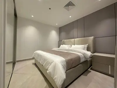 a bedroom with a large bed with white sheets at Damac Tower Amman Luxury Apartments - استوديوهات وشقق فاخرة - داماك عمان العبدلي in Amman
