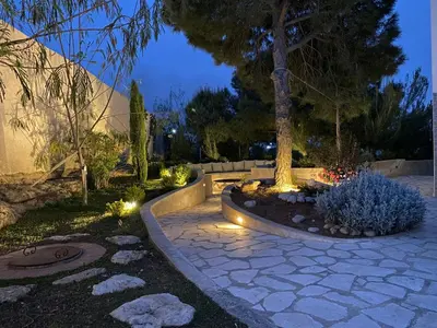 a garden at night with a tree and lights at Qaimariya Farmhouse Amman - Day Use - Lodging - Events in Amman