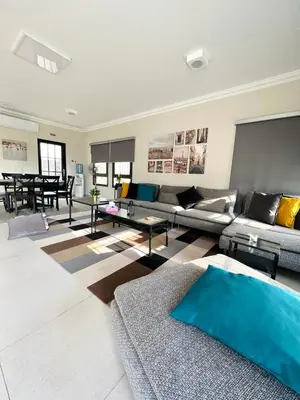 a living room with a couch and a table at Qaimariya Farmhouse Amman - Day Use - Lodging - Events in Amman