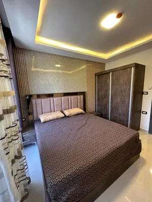a bedroom with a large bed with a wooden headboard at modern 2bedroom for rent Abdoun in Amman