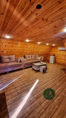 a living room with a couch and a table in a wooden ceiling at Widian al-sham huts in Jerash