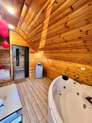 a bath tub in a room with wooden walls at Widian al-sham huts in Jerash