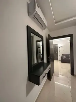 a bathroom with a mirror on a wall with a dresser at modern 2bedroom for rent abdoun2 in Amman