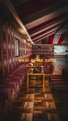 a restaurant with benches and a table in a room at wadi novas camp in Wadi Rum