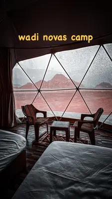 two chairs and a tent with a view of the desert at wadi novas camp in Wadi Rum