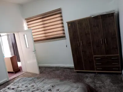 a bedroom with a wooden cabinet and a window at petra sun apartment in Wadi Musa