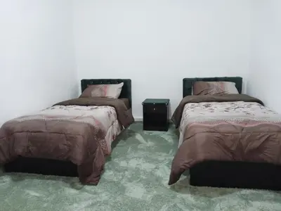two beds sitting next to each other in a room at petra sun apartment in Wadi Musa