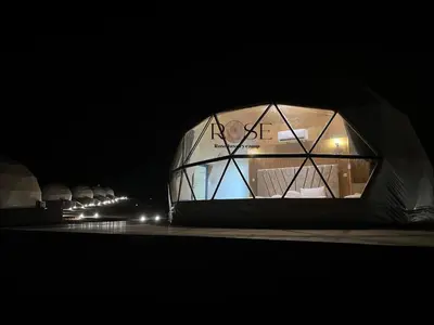 a dome shaped building with lights in the dark at Wadi Rum Rose Luxury camp in Wadi Rum