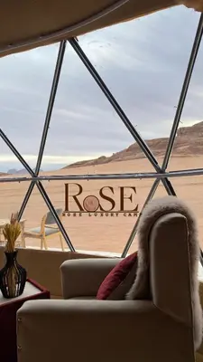 a view of the desert from a window with a couch at Wadi Rum Rose Luxury camp in Wadi Rum