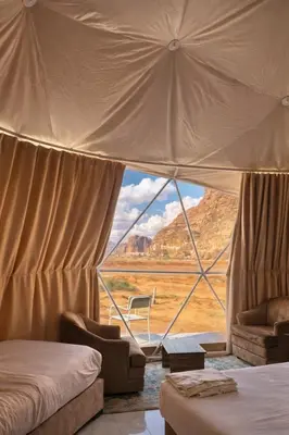 a bedroom with a view of the desert from a tent at Sidra Luxury Camp in Rum in Wadi Rum