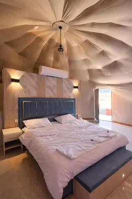 a bedroom with a large bed with a wooden ceiling at Sidra Luxury Camp in Rum in Wadi Rum