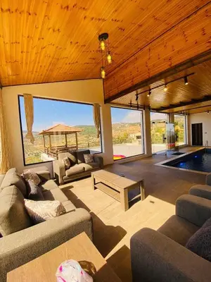 a living room with couches and a swimming pool at Souf view in Jerash