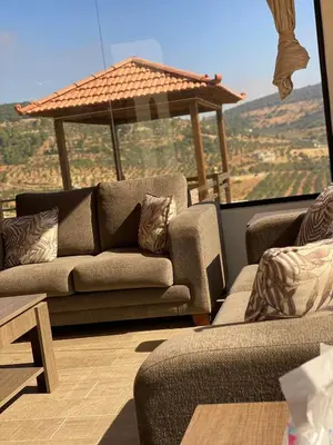 a living room with two couches and a large window at Souf view in Jerash
