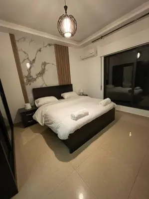 a bedroom with a large bed and a large window at apartment 60m 1bedroom for rent2 in Umm Uthainah