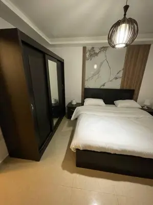 a bedroom with a large bed and a chandelier at apartment 60m 1bedroom for rent3 in Umm Uthainah