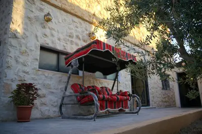 a chair with an umbrella in front of a building at Mansi Residence in Wadi Musa