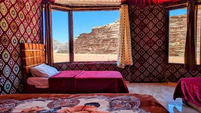 a room with two beds and a view of the desert at WhyDesert Camp & Tours in Wadi Rum