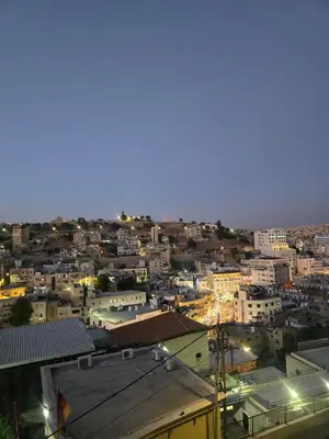 a view of a city at night at Downtown Living Boutique Apartments in Amman
