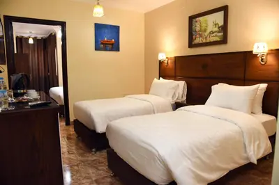 a hotel room with two beds and a mirror at Karam Inn in Aqaba