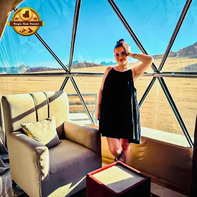 a woman in a black dress standing next to a couch at MAGIC RUM lUXURY HUSSEN in Wadi Rum