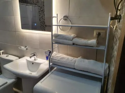 a bathroom with a sink and a toilet and towels at Suad Apartment in Amman