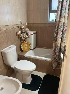 a bathroom with a toilet and a tub and a sink at 3 bedroom apartment in Ţāb Kirā‘