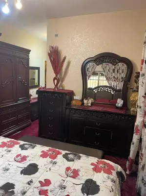 a bedroom with a bed with a dresser and a mirror at 3 bedroom apartment in Ţāb Kirā‘