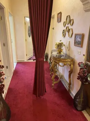 a room with a red curtain and a table at 3 bedroom apartment in Ţāb Kirā‘