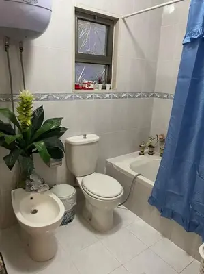 a bathroom with a toilet and a sink and a tub at 3 bedroom apartment in Ţāb Kirā‘