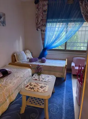 a room with two beds and a table in it at 3 bedroom apartment in Ţāb Kirā‘