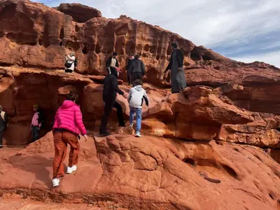 a group of people walking on the rocks at Wadirum winter in Wadi Rum