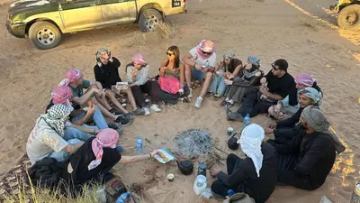 a group of people sitting in the sand at Wadirum winter in Wadi Rum