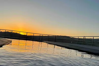 a body of water with the sunset in the background at Farmhouse with Pool and Breathtaking Views in Amman