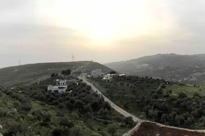 a winding road on a hill with houses on it at Farmhouse with Pool and Breathtaking Views in Amman